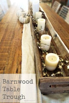 a wooden table with candles on it and the words barnwood table trough written in white