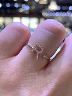 a person's hand holding a ring with the letter p on it