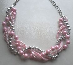 a pink and silver beaded necklace on a white surface