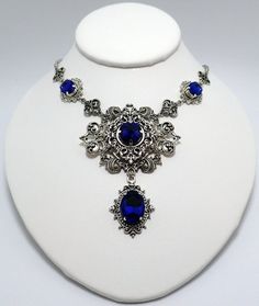 This is a new handmade necklace. It is made with antiqued silver plated filigrees, accented with high quality DARK COBALT BLUE glass rhinestones. Decorated portion is 7" wide and 3 1/4" tall in the center. Necklace is adjustable 15-18" with a lobster clasp and chain extender. If you would like a different length, please send us a message. Gothic Blue Metal Jewelry, Blue Gothic Metal Necklace, Blue Gothic Metal Jewelry, Handmade Gothic Blue Necklace, Handmade Blue Gothic Necklace, Blue Victorian Metal Jewelry, Victorian Jewelry Necklace, Dark Blue Necklace, Dark Blue Jewelry