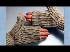 two hands are shown with knitted gloves on them