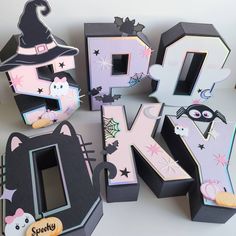 the letters are made out of paper and decorated with cats, witches, and bats