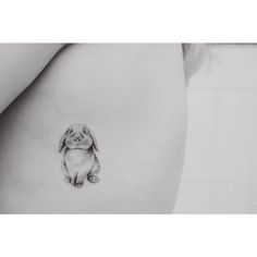 a small dog tattoo on the side of a woman's stomach, which is drawn in black and white