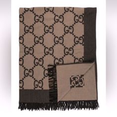 a gucci scarf with a black and brown pattern on the front, two matching scarves are laying side by side