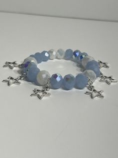 This Bracelet features beautiful blue and white beads that shine like stars when they catch the light and silver star charms to add that celestial feel of having the sky dance on your wrist.  Perfect for a Celestial Goddess wanting a touch of magic or to complete that pastel outfit with this versatile bracelet! Created with durable beads and heavy duty elastic string.  Made in 7.5 inches but can be customized to fit in either 7 inches or 8 inches. 7 inches is recommended for very small wrist whi Blue Beaded Star-shaped Bracelets, Blue Beaded Bracelets With Star Charm, Blue Bracelets With Star Charm And Round Beads, Blue Beaded Bracelets With Star Charm For Gift, Celestial Bracelet, Celestial Goddess, Goddess Bracelet, Crystal Bead Jewelry, Blue Beaded Bracelets