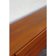 a close up of a wooden table with two drawers on it's sides and a white wall in the background