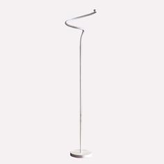 a white floor lamp that is on top of a table