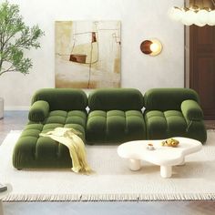 a modern living room with green velvet sofas and white coffee table in the center