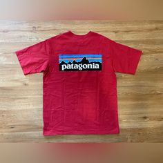 Add Some Eco-Friendly Style To Your Wardrobe With This Patagonia Men's P-6 Logo Responsibili-Tee T-Shirt In Sumac Red. The Short-Sleeved Tee Features A Solid Pattern With A Crew Neck And A Regular Fit, Making It A Comfortable Option For Everyday Wear. The Shirt Is Made From High-Quality Materials With Double-Sided Features And Accents, Including The Iconic Patagonia Logo. This Red Tee Is Perfect For Men Who Want To Show Off Their Love For The Outdoors While Maintaining A Stylish And Eco-Friendly Look. It's Available In Size Small And Is Sure To Become A Staple In Any Wardrobe. Red Short Sleeve T-shirt For Outdoor, Casual Red T-shirt For Outdoor Activities, Red Cotton Tops For Outdoor Activities, Sporty Red Tops For Outdoor Activities, Red Crew Neck Top For Outdoor Activities, Red Short Sleeve T-shirt For Outdoors, Red Cotton Tops For Outdoor, Red Short Sleeve Tops For Outdoor, Patagonia Graphic Cotton T-shirt