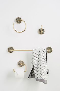 the bathroom is decorated with gold and black accessories, including towels, toilet paper holder, towel ring, and wall hooks