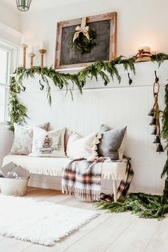 a living room filled with lots of furniture and christmas wreaths on the wall above it