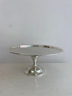 a silver cake plate sitting on top of a table