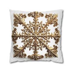 a gold and white pillow with an intricate design