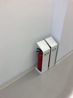 two white boxes sitting on the floor next to each other in an empty room with no people