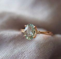 a ring with an oval cut aqua blue topazte surrounded by two small diamonds