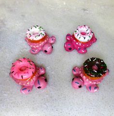 three pink toys with donuts and sprinkles on them sitting on the floor