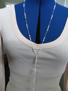 Swarovski crystal ab bicones and white 4mm freshwater pearls are knotted on 100% silk making a beautiful lariat style necklace that can be worn 3 ways. This would be a perfect addition to any bride's rehearsal dinner outfit as well as any other occasion. Lariat is 42 inches long and is made to order. Can be made longer or shorter if needed. Available in other color options elsewhere in my shop. Contact me with any questions. Thank you for visiting my shop and have a great day! Luxury Tarnish-resistant Lariat Jewelry, Adjustable Pearl White Lariat Necklace, Adjustable Long Lariat Necklace With Pearl Drop, Adjustable Lariat Pearl White Necklace, Elegant Adjustable Lariat Necklace With Round Beads, Adjustable Elegant Lariat Crystal Necklace, Elegant Adjustable Lariat Crystal Necklace, Elegant Adjustable Beaded Lariat Necklace, Pearl White Pearl Lariat Necklace