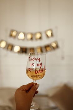 a person holding a wine glass with the words today is my day written on it