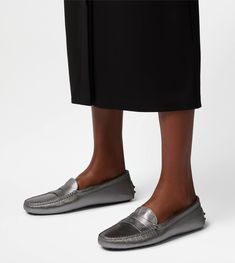 Tod's Gommino interprets informal and casual elegance. Result of careful craftsmanship, they are here proposed in metallic leather, with penny bar, stamped Tod's monogram and the iconic rubber pebble outsole. Gray Leather Loafers With Rubber Sole, Silver Leather Loafers With Round Toe, Gray Leather Loafers With Flat Heel, Silver Leather Loafers For Work, Gray Leather Formal Loafers, Gray Leather Loafers For Formal Occasions, Formal Gray Leather Loafers, Luxury Silver Loafers With Round Toe, Designer Silver Loafers With Leather Sole