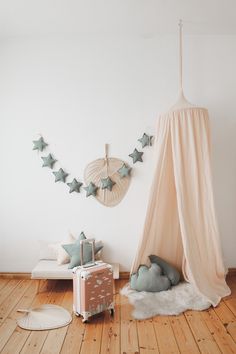 a room with a bed, suitcase and some decorations on the wall above it is a canopy tent