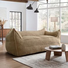 a living room filled with furniture and a large window covered in lots of natural light