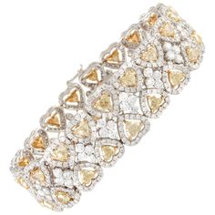 A 18-karat white and yellow gold diamond bracelet with two rows of heart shape diamonds with white diamond halos. There are 38 Fancy Yellow heart diamonds that weight about 13.50 carats with a VS clarity. There are 612 round white diamonds that weigh about 12.54 carats with a G-H color and VS clarity. Total diamond weight for the bracelet: ~26.04 carats. Gold Diamond Bracelet, Heart Shaped Jewelry, Yellow Heart, Bracelets Gold Diamond, Expensive Jewelry, Heart Shaped Diamond, Diamond Bracelets, Yellow Diamond, Diamond Heart