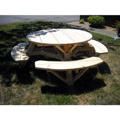 a wooden picnic table sitting in the grass