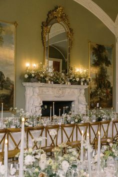 a table set up with white flowers and candles