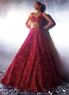 Make a bold statement in the exquisite Red Sequins Embroidered Bridal Lehenga with Veil, crafted from luxurious soft net fabric. The flowing red lehenga is intricately embroidered with tonal sequins, crystals, glass beads, and hand-dyed pearls, creating a design that shimmers with opulence. Paired with an intricately embroidered blouse, perfectly complementing the lehenga’s lavish details. The look is completed with a matching dupatta and a long veil, both bordered and embellished to perfection. This ensemble masterfully blends tradition with contemporary style, ensuring that the bride or bride-to-be stands out with elegance and grace on her special day. Composition : Lehenga, Blouse, Veil and Dupatta - Net Care: Dry Clean Only and Vacuum Storage This product can be customized for sleeves, Elegant Red Lehenga With Sequins, Red Anarkali Dress With Sequins, Red Sequined Sharara For Wedding, Red Sequined Wedding Set, Red Wedding Sets With Sequins, Red Sequined Choli For Wedding, Red Sequined Sets For Reception, Red Sequined Wedding Choli, Red Lehenga With Sequins And Traditional Drape