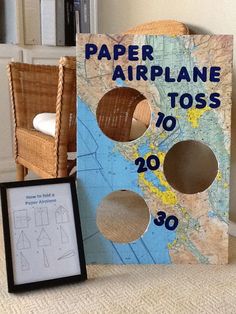 a paper airplane toss game sitting on top of a table next to a photo frame