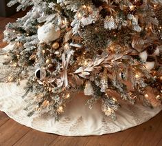 a white christmas tree with gold and silver ornaments