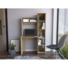 a computer desk sitting in front of a window next to a chair and bookshelf