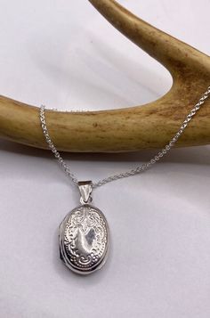 "Vintage Silver Locket Necklace  The Tiny Oval Photo Locket measures about 1/2 inch long (without the bale), features a lovely etched design and is the perfect necklace for a small photo or other memory  Paired with a delicate 925 Sterling Silver Chain available in lengths of 16, 18 ,20, 22\" or 24\" We recommend using a laminated photo for longevity  Thank you for supporting a small veteran owned business! All jewelry is shipped free within the US in a stylish gift box" Classic Silver Locket Necklace With Oval Link, Classic Silver Oval Link Locket Necklace, Sterling Silver Locket Necklace With Oval Link, Sterling Silver Oval Link Locket Necklace, Silver Sterling Silver Locket Necklace With Oval Link, Classic Sterling Silver Oval Link Locket Necklace, Classic Engraved Locket Necklace With Oval Link, Silver Stamped Oval Pendant Jewelry, Antique Silver Sterling Silver Oval Locket Necklace