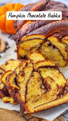 sliced cinnamon swirl bread sitting on top of a cooling rack next to pumpkins and chocolate chips