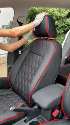 the interior of a car with black and red stitching on the front seat covers