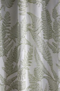 a close up view of a curtain with green leaves on it