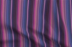 a close up view of a purple and blue crocheted blanket with horizontal stripes