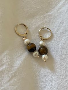 Earrings named "Mary" - Mini hoop with a ring  diameter of the hoop 12mm  ring diameter 1.20mm  stainless steel material gilded with fine gold  nickel free, lead free, cadmium free - Rod gilded with fine gold x1 - Tiger's Eye Bead x1 - Freshwater pearl 7-8mm x2 🛠 Handmade All jewelry is made by hand in my workshop in Paris. For this reason, each piece is unique and may differ from the photo, that's also the beauty of handmade! 🧡 Maintenance - For stainless steel and gold-plated jewelry, you ca Diy Pearl Jewelry, Jewelry Portfolio, Pearls Diy, Freshwater Pearl Jewelry, Tiger Eye Beads, Classic Jewelry, Tiger's Eye, Jewelry Earrings Hoops, Steel Material