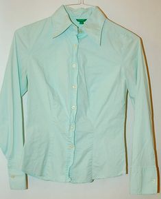 Mint green in color by United Colors of Benneton shoulder to shoulder measured flat is 14 inches underarm to underarm measured flat is 16 inches 22 inch sleeve length 23 inch overall length solid construction and workmanship extra buttons stretch cotton darts in front and back yoke in back detailed center back panel a Benneton classic in excellent condition Classic Green Office Blouse, Classic Green Blouse For Work, Green Stretch Tops With Button Closure, Green Stretch Blouse For Work, Green Collared Blouse For Office, Green Slim Fit Button-up Top, Green Slim Fit Summer Tops, Green Slim Fit Tops For Summer, Green Stretch Tops With Buttons