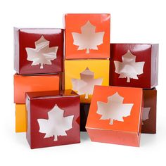 a group of different colored boxes with maple leaves cut out of them in the middle