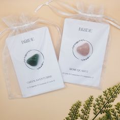 two bags with stones in them sitting on top of a table next to some plants