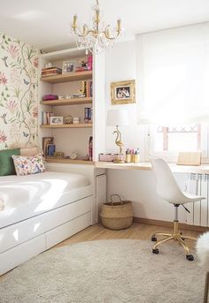 a room with a bed, desk and chair in it next to a wallpapered wall