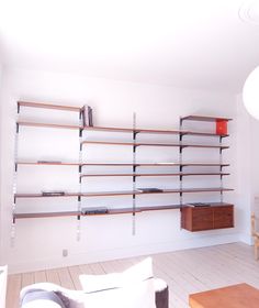 a living room filled with furniture and bookshelves next to a wall mounted book shelf