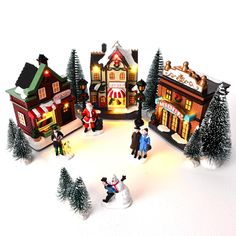 a group of toy figurines that are standing in the snow with christmas decorations around them