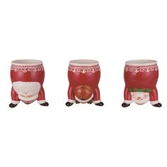 three red and white christmas decorations with santa clause on the bottom one holding a sack