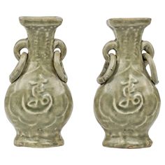 two vases with designs on them sitting side by side