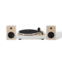 a record player and speakers on a white surface