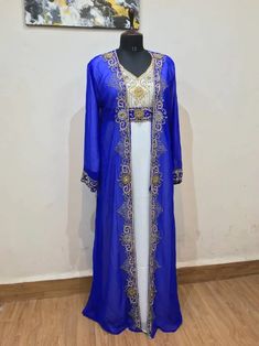 This Royal Blue & White Hand Beaded Moroccan Kaftan is a stunning piece of craftsmanship designed for ceremonial occasions. Made from soft, flowy georgette fabric, this kaftan features intricate hand embroidery and delicate zari work, elevating your look to a designer level. The full sleeves and V-neckline offer a regal aesthetic, making this two-piece jacket style kaftan a must-have in your wardrobe. Available in sizes XS to 6XL for a perfect fit. Embellished Long Sleeve Georgette Kaftan, Long Sleeve Georgette Kaftan With Dabka Work, Traditional Long Sleeve Georgette Abaya, Long Sleeve Georgette Kaftan For Party, Embroidered Long Sleeve Georgette Kaftan, Party Long Sleeve Georgette Kaftan, Long Sleeve Georgette Kaftan With Zari Work, Long Sleeve Georgette Kaftan For Eid, Long Chiffon Kaftan For Eid