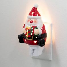 a light that is on the wall with a santa clause figure hanging from it's side