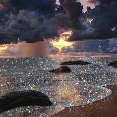 some rocks and water under a cloudy sky